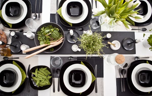 Una tavola in bianco e nero con piante, cibo e tovaglioli verdi - IKEA