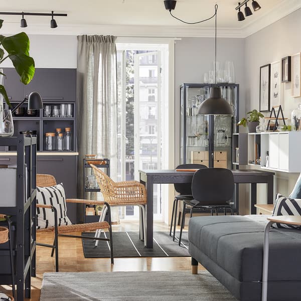 Una zona pranzo e un soggiorno in stile coordinato con mobili in rattan nei colori marrone, grigio e antracite - IKEA