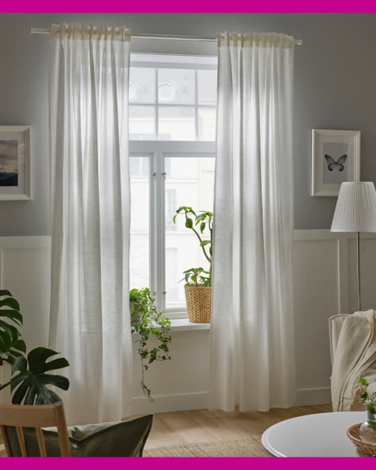 Unas cortinas de velo cubren la luz que entra a un living.