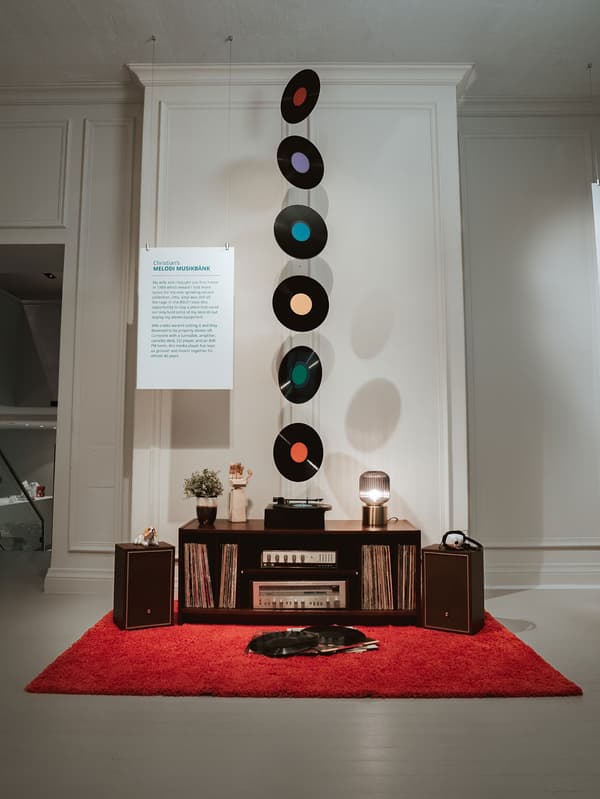 Une armoire de rangement ouvert de présentation MELODI contient un équipement stéréo et une collection de disques.