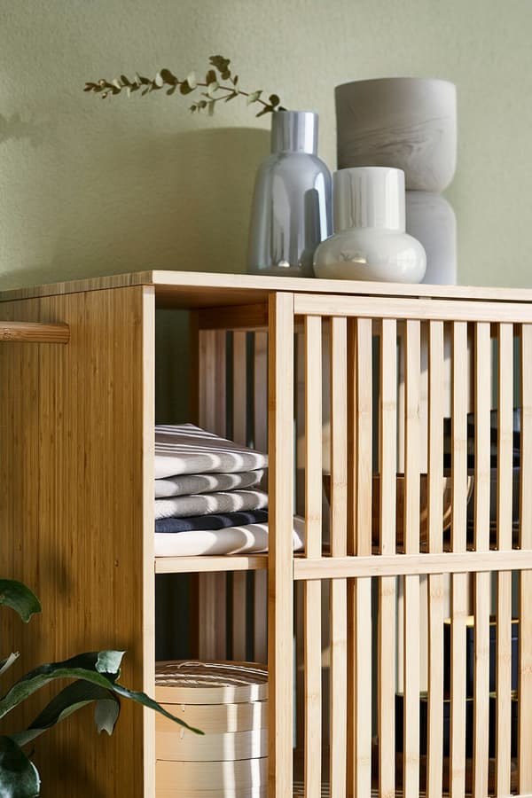 Une armoire en bambou avec des plantes et des vases.