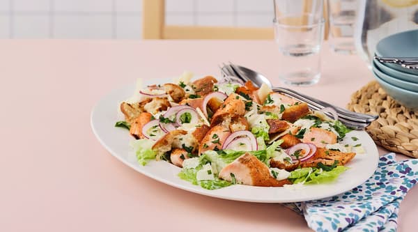 Une assiette de salade César croustillante et de saumon grillé