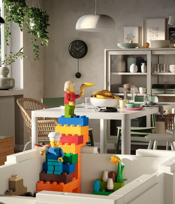 Une boîte BYGGLEK blanche sans couvercle d’où sort un escalier coloré construit à partir de briques LEGO.