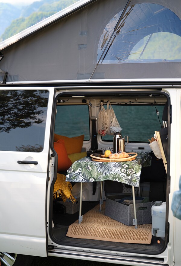 Une camionnette à portes ouvertes avec une table de pique-nique à l'intérieur.