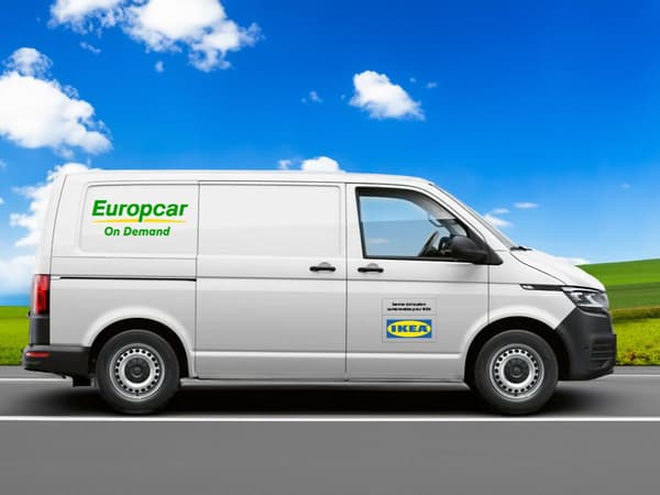Une camionnette blanche roule sur une route de campagne