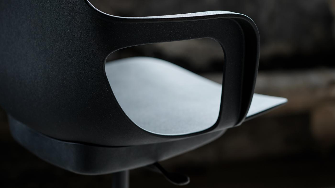 Une chaise pivotante ODGER anthracite dans une pièce peu éclairée.