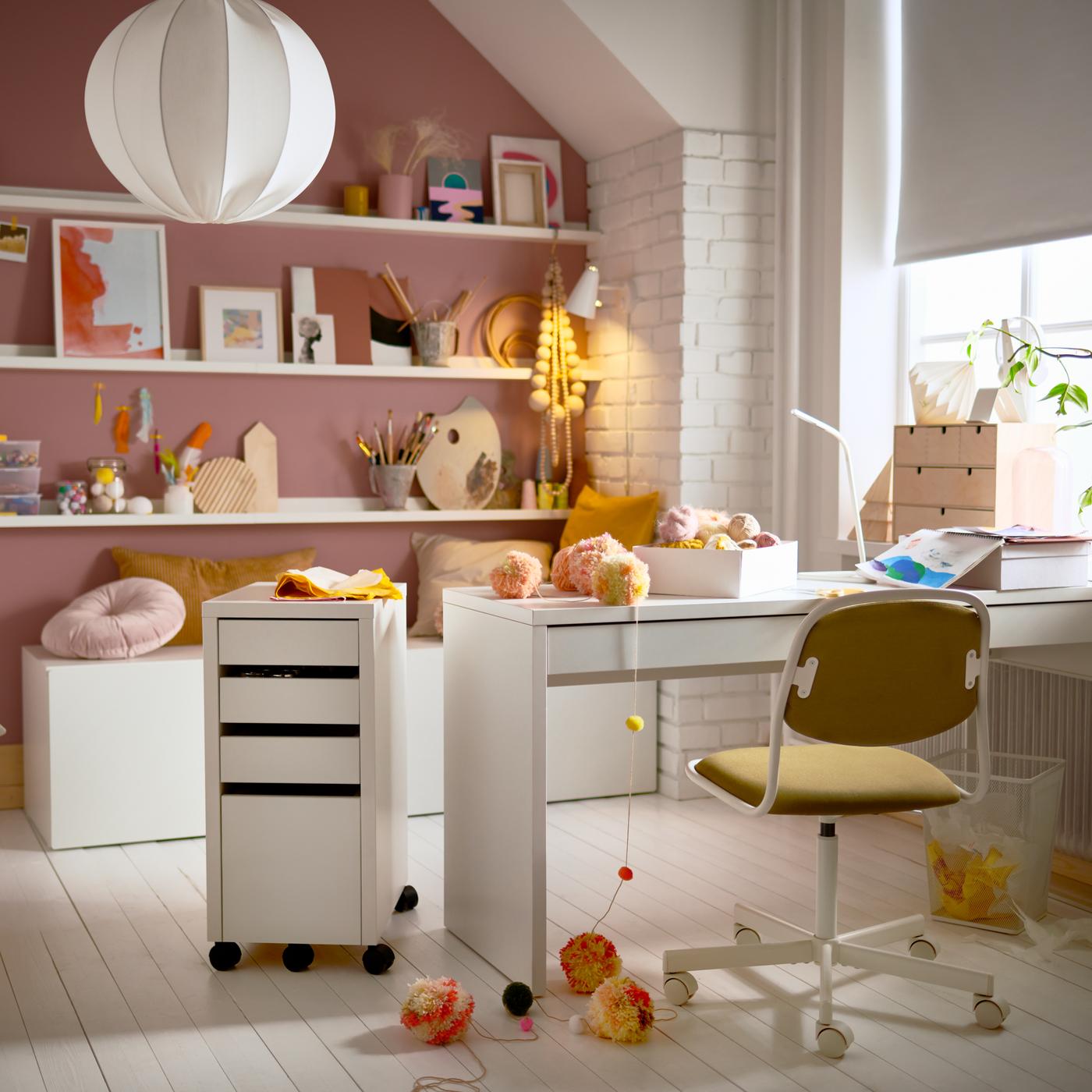 Une chambre d’ado avec un bureau MICKE, une chaise de bureau pour enfant, un caisson à tiroirs blanc et des étagères pour photos garnies d’objets décoratifs.