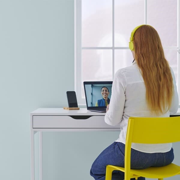 Une cliente est devant son ordinateur pour effectuer une conception à distance avec un collaborateur IKEA