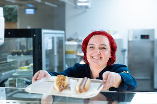 Une collaboratrice IKEA qui sert un plateau repas au restaurant