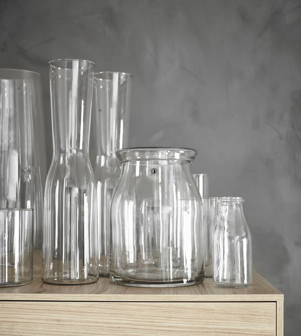 Une collection de vases en verre traditionnels et modernes trône sur le dessus d’une armoire haute.