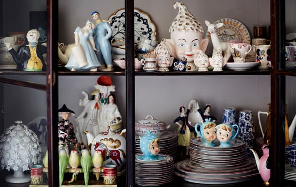 Une collection d’objets de décoration en porcelaine dans une vitrine.