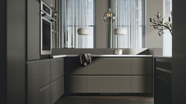 Une cuisine avec des façades UPPLÖV anthracite, des suspensions BLÅSVERK beiges et un four mural TÄNGBY en acier inoxydable.