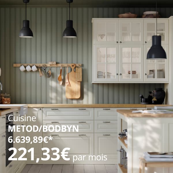 Une cuisine moderne avec des armoires blanches, des plans de travail en bois, un îlot avec des tabourets, des suspensions noires et un porte-ustensiles en bois au-dessus du plan de travail.
