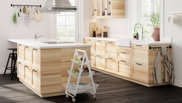 Une cuisine ouverte avec des portes vitrées traditionnelles en frêne naturel, des armoires en frêne, un îlot de cuisine et un plancher en bois foncé.