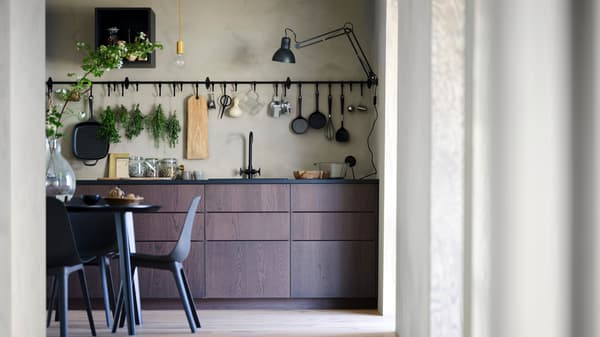 Une cuisine SINARP avec une table et des chaises ainsi qu'un rail et un crochet HULTARP accrochés au mur.