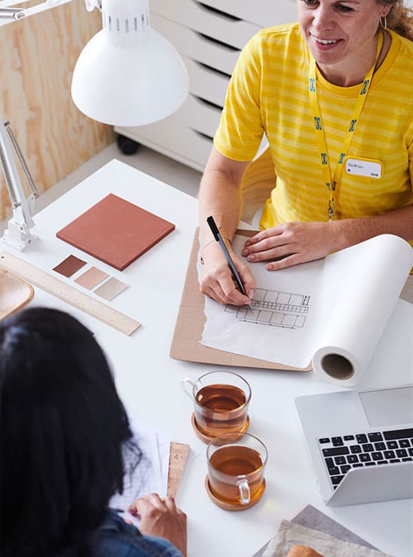 Une designer d'intérieur fait la planification d'une pièce en compagnie d'une cliente.