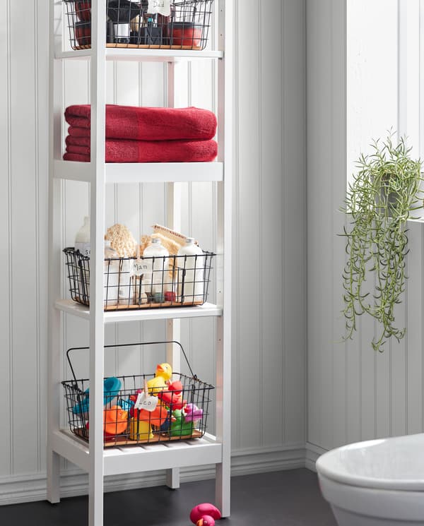 Une étagère HEMNES blanche avec des corbeilles en fil PLEJA noires pour les serviettes, les jouets de bain, le matériel pour spa et bien plus, disposées sur les quatre tablettes.