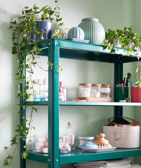 Une étagère KOLBJÖRN à moitié remplie d’un mélange d’objets de décoration et de rangement: plantes, récipients, accessoires de salle de bain.