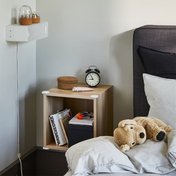 Une étagère murale avec des protections d’angle blanches sur les côtés pour que les enfants puissent se déplacer en toute sécurité.