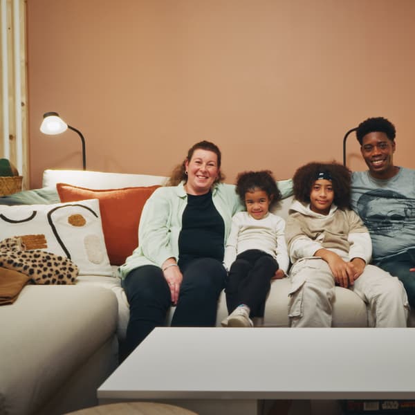 Une famille, deux parents, deux enfants, assis sur leur canapé