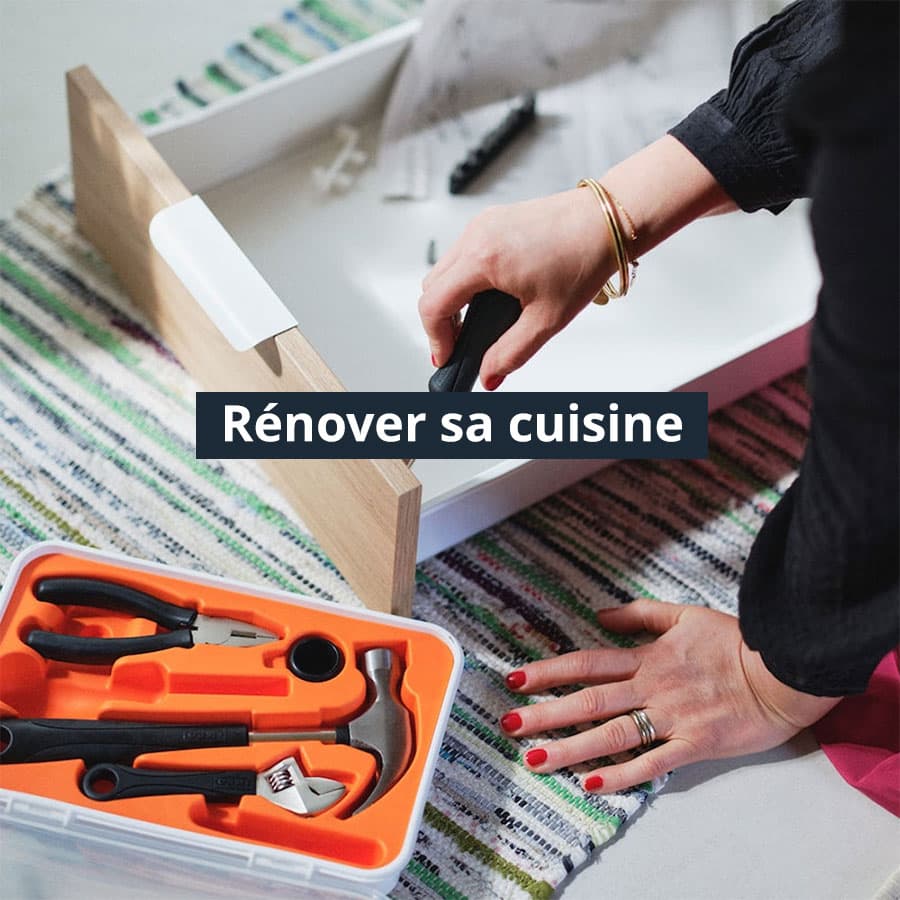 Une femme entrain de monter un tiroir de cuisine avec sa boîte à outils IKEA posée sur le côté.