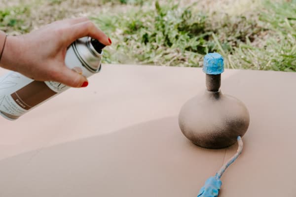Une femme est en train de bomber un pied de lampe en marron