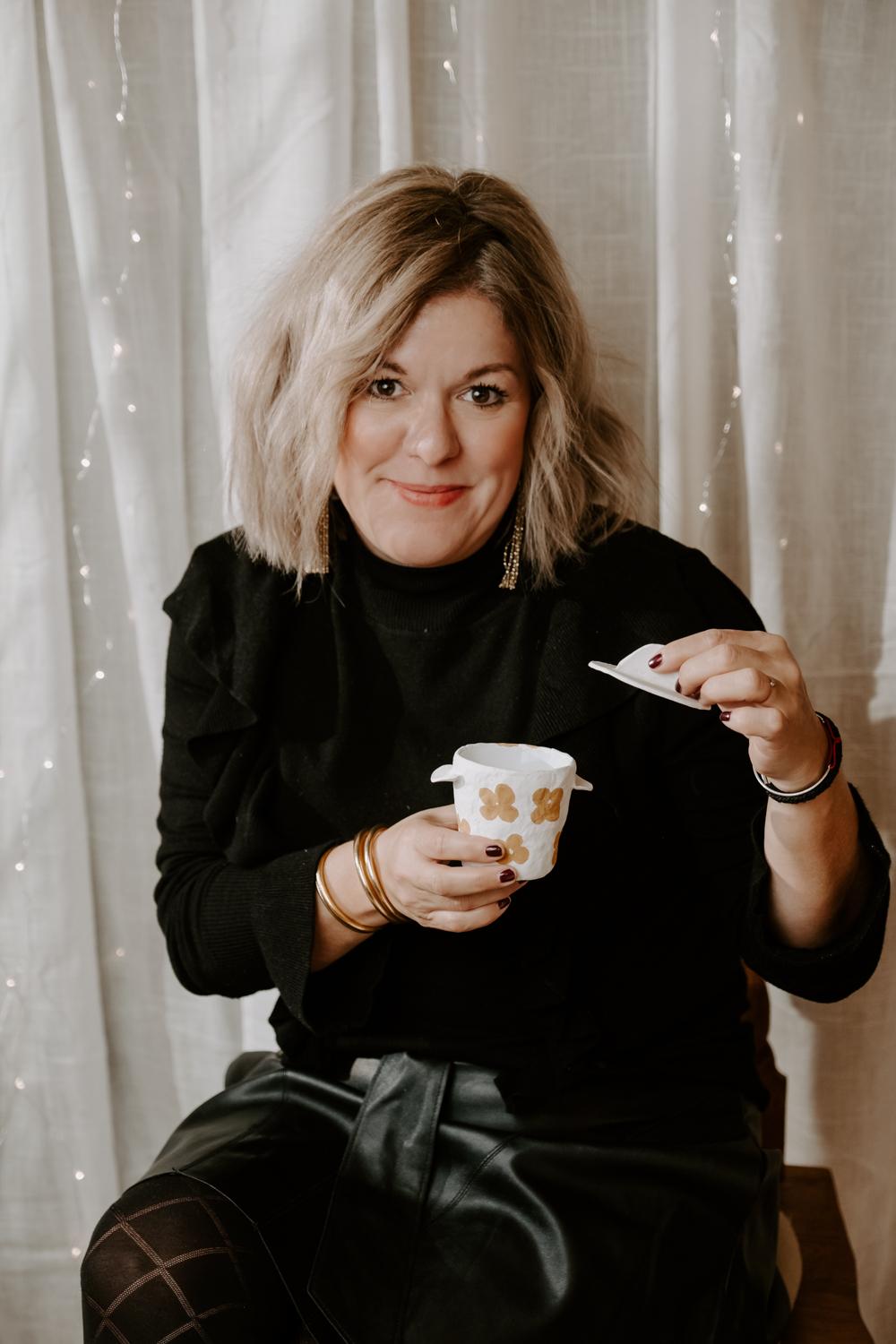 Une femme tient dans sa main un objet avec un couvercle ouvert