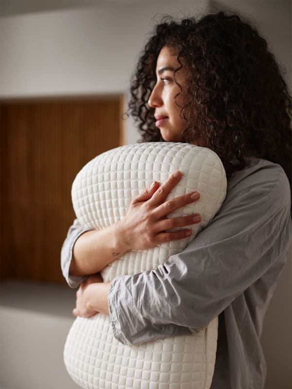une femme tient un oreiller
