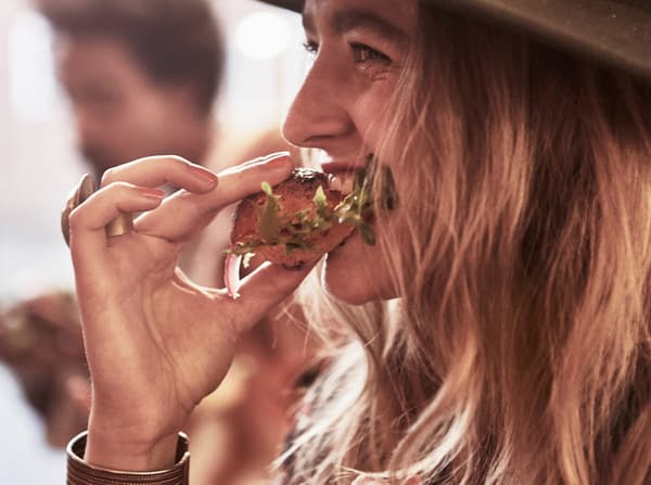 Une fille dégustant un encas avec du pain et de la salade.