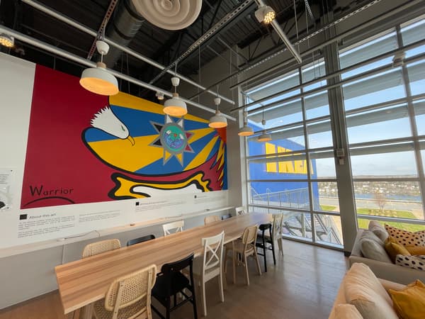 Une grande murale est exposée dans un bâtiment très lumineux. 