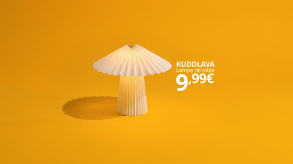 Une lampe de table blanche à 9,99 € sur un fond jaune orangé