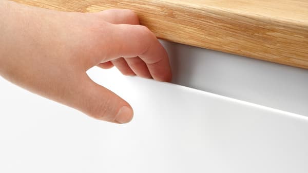 Une main ouvrant un tiroir de cuisine