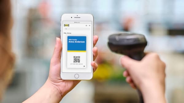 Une main scanne le code QR IKEA Family