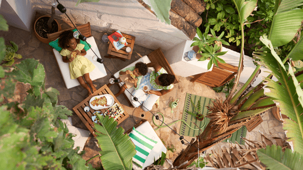 Une maman et ses deux enfants déjeunant dans le jardin.