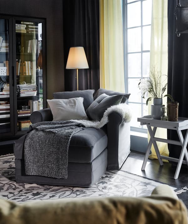 Une méridienne GRÖNLID garnie d’une housse TALLMYRA en gris moyen et de coussins dans un séjour.