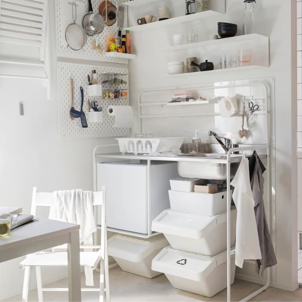 Une mini cuisine IKEA SUNNERSTA blanche avec des étagères accrochées au mur.