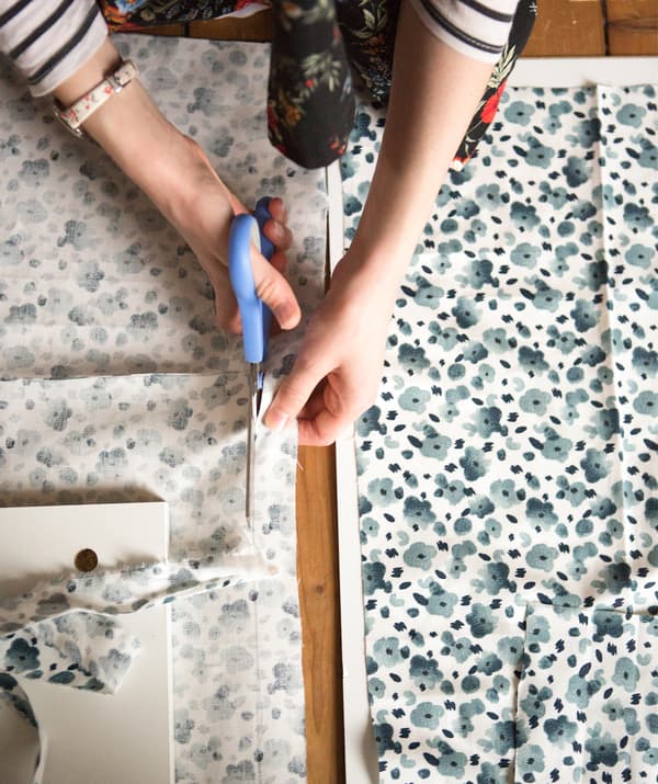 Une personne coupant du tissu au motif floral bleu