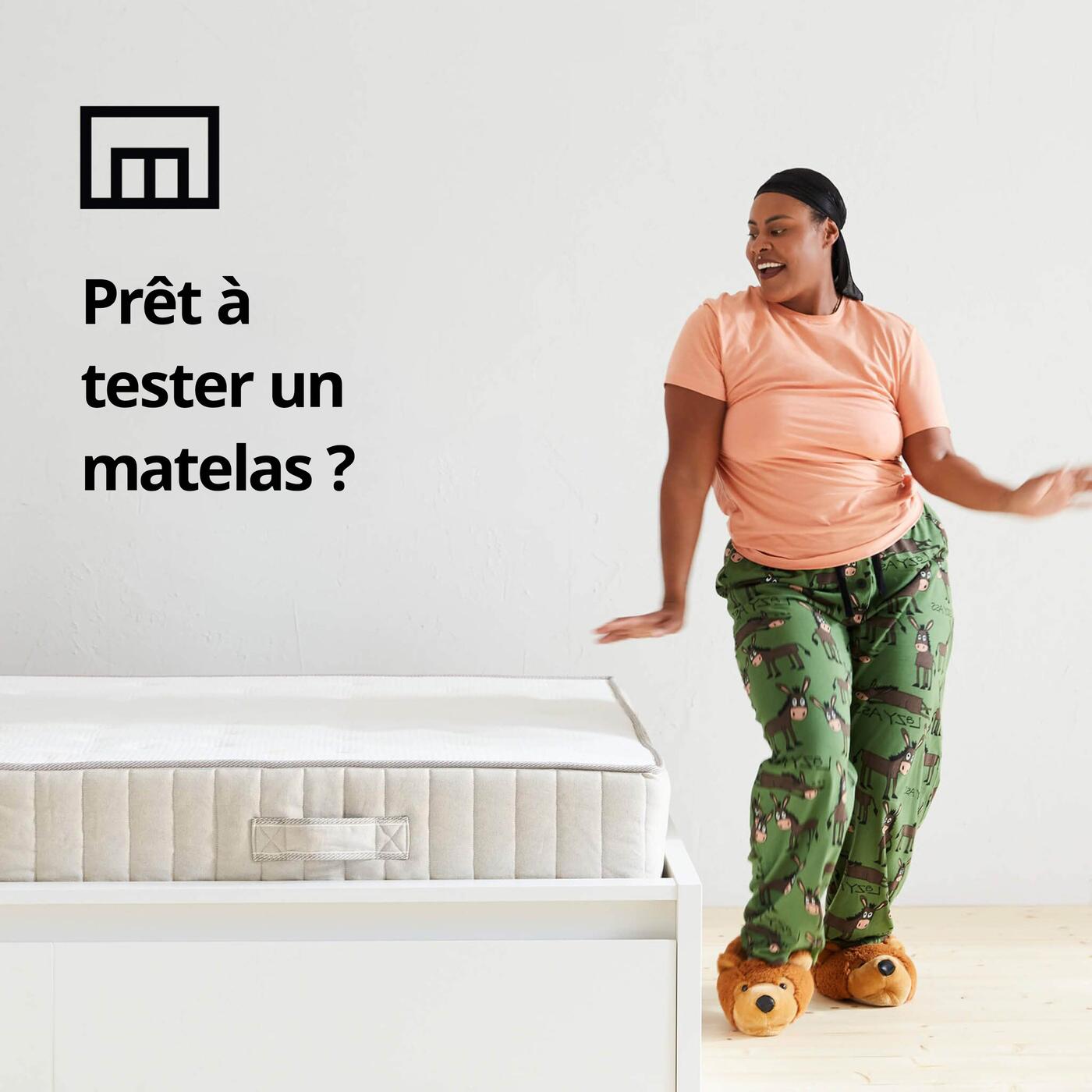 Une personne debout en pyjama à côté d'un lit avec le texte : « Prêt à tester un matelas ? » 