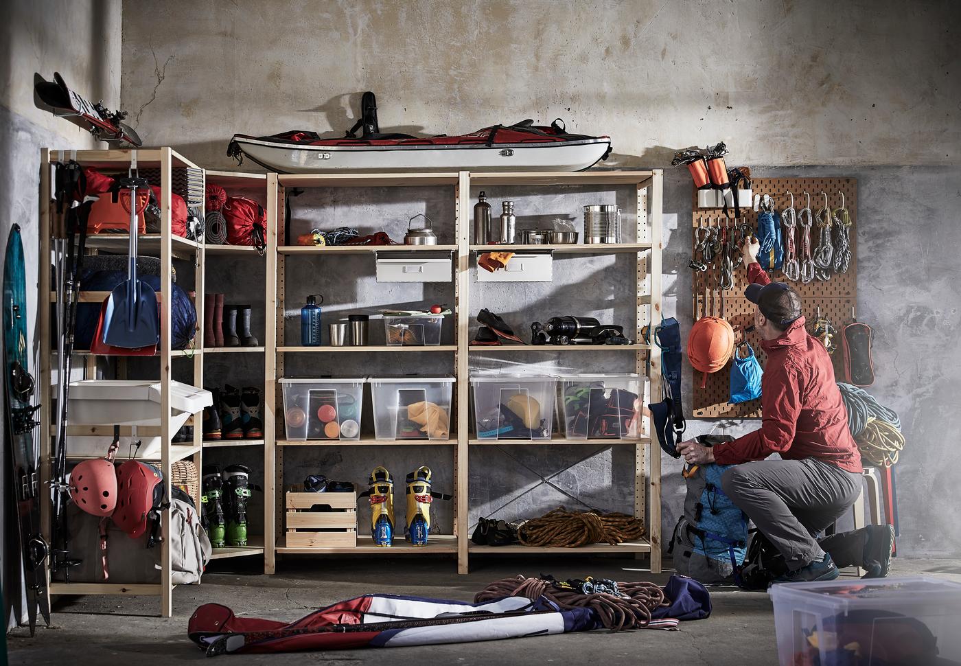 Une personne prend un outil à côté d'étagères IVAR formant un angle dans un garage.