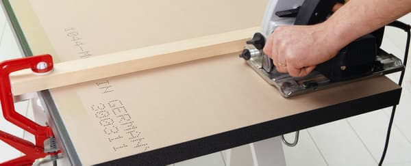 Une personne qui découpe un plan de travail 