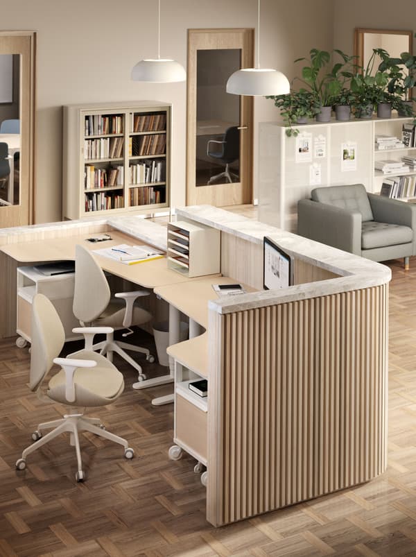 Une réception constituée de deux bureaux BEKANT côte à côte, avec deux chaises HATTEFJÄLL et deux rangements mobiles BEKANT.