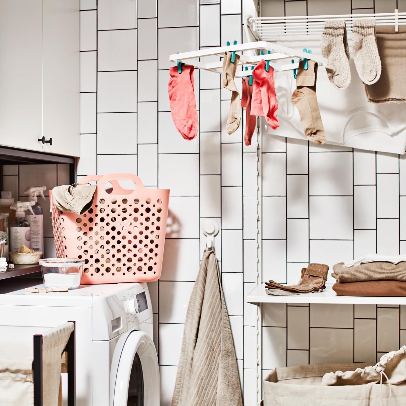 Une salle de bain avec un lave-linge, une combinaison de rangement avec armoire pour la buanderie, et un rangement de buanderie avec une étagère.