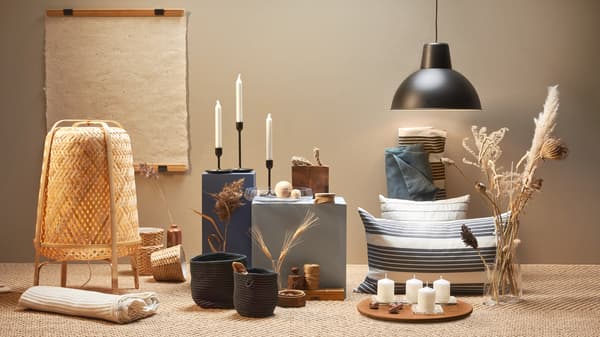 Une sélection de produits IKEA provenant de sources durables, dont le lampadaire KNIXHULT, du linge de lit en coton, des bougies, des tapis et des vases.