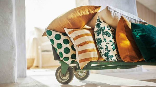 Une série de coussins aux couleurs printanières sur un diable à roulettes.