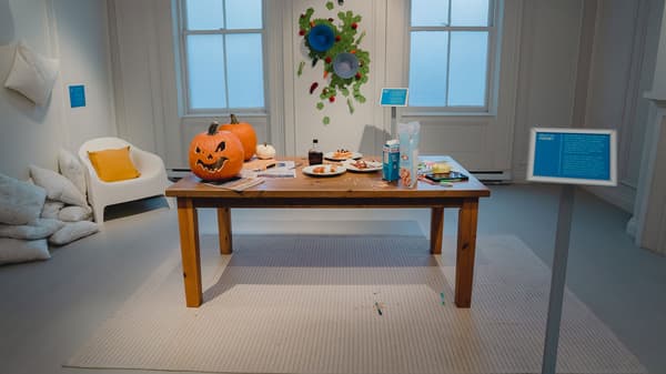 Une table à manger FORSBY de présentation sur laquelle sont posées des citrouilles découpées, des assiettes de nourriture, de lait et de céréales, et de la peinture pour enfants.