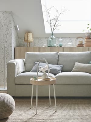 Une table d'appoint se trouve devant un canapé-lit 2 places VIMLE dans un salon aux couleurs scandinaves.
