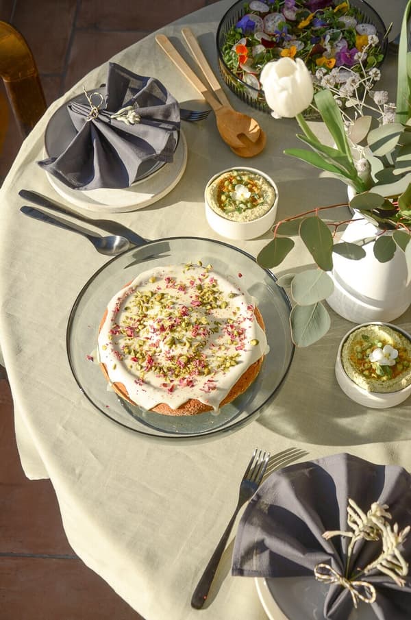 Une table décorée au printemps avec un gâteau au milieu.