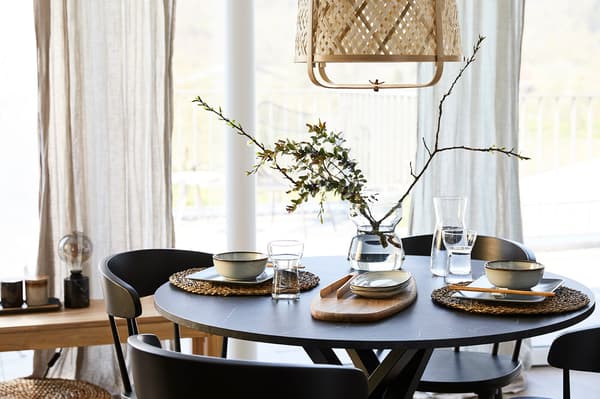 Une table est mise pour un repas, avec un vase au milieu de la table.