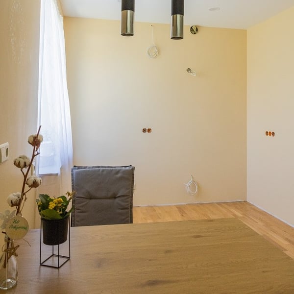 Unfinished dining room wall with visible electrical outlets and cables ready for kitchen installation
