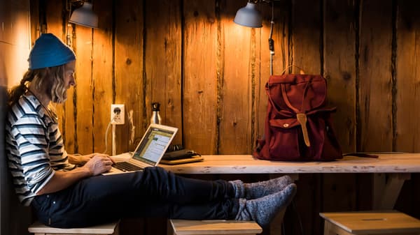 Ung man sitter vid en arbetsbänk som är uppsatt på en vägg med synlig panel.